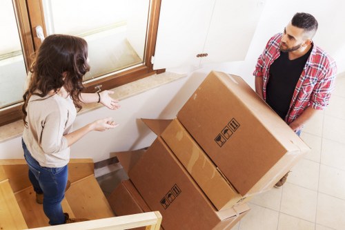 Removal workers carrying items through a Wandsworth flat stairwell
